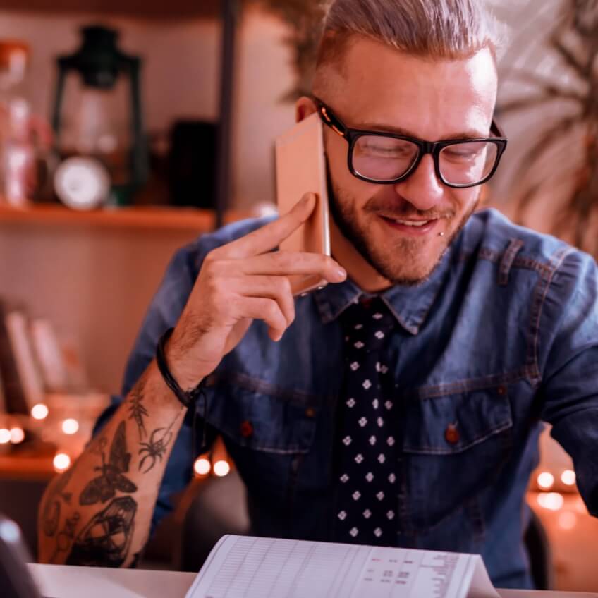 Foto de um homem de terno sorrindo com documentos em mãos