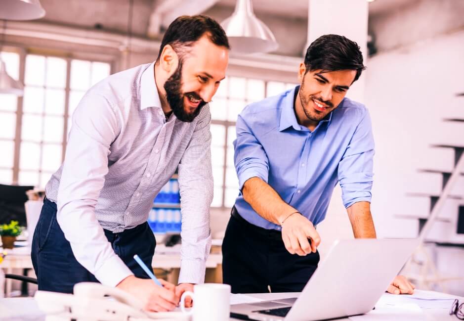 Imagem de 2 homens fazendo anotações e conversando
