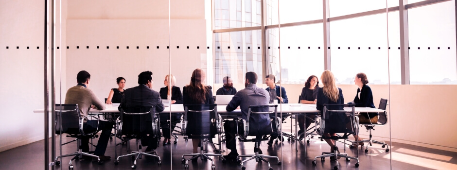 Mesa de reunião com muitas pessoas conversando entre elas