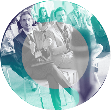 Um circulo com a imagem de um grupo de pessoas sentadas aplaudindo.
